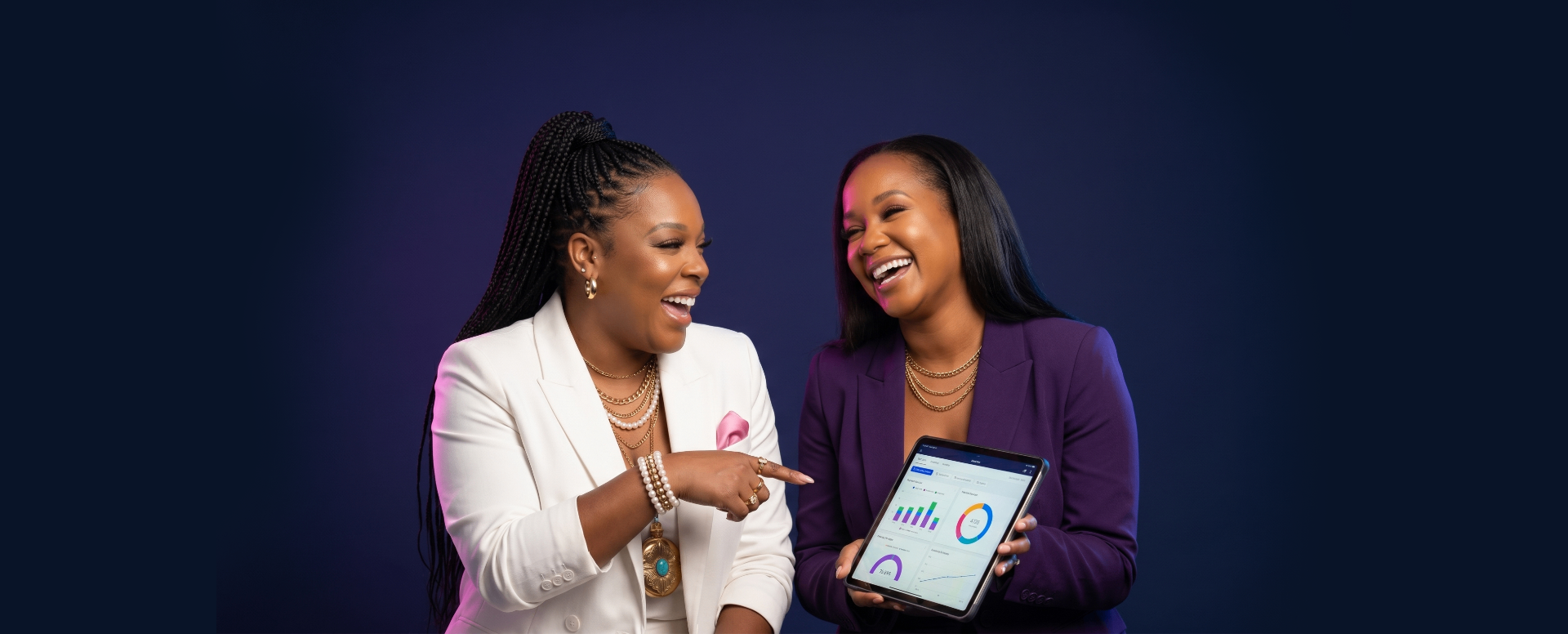 Coach Algernae King and Denesha laughing together holding a tablet.