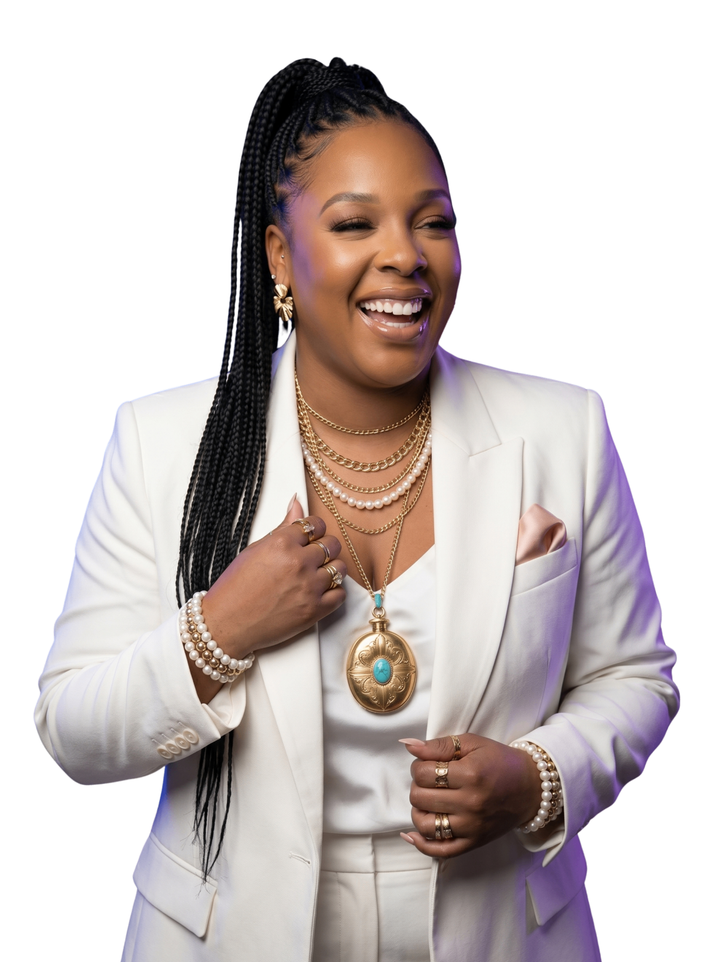 Denesha laughing in a white suit with gold jewelry.